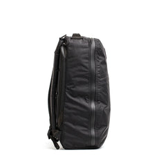 Side view of black GORUCK tactical backpack with padded straps and weather-resistant zippers on white background