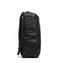 The GR1 USA - Waterproof X-PAC backpack, shown upright and side-on against a white background, is a black rucksack ideal for carrying and protecting your durable gear.