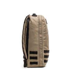Side view of the tan GR1 USA - Cordura backpack with black straps and zippers, standing upright against a white background. This everyday carry rucksack is built for durability and daily use.