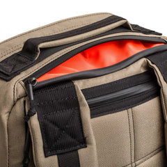 A tan and black GR1 USA - Cordura rucksack with a zipper open, showing off its bright orange interior—built with Special Forces-grade durability for your everyday carry.