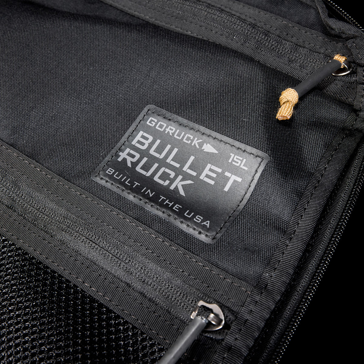 Close-up of a black Bullet Ruck USA Throwback daypack with a visible label, zippers, and durable CORDURA® construction.