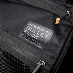 Close-up of a black Bullet Ruck USA Throwback daypack with a visible label, zippers, and durable CORDURA® construction.