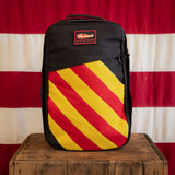 A limited edition Shooter 26L Flash Buffalo Fuzz - Built by Scars sits on a box before a striped flag.