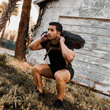 Man doing outdoor rucking squats in GORUCK gear with a sandbag backpack