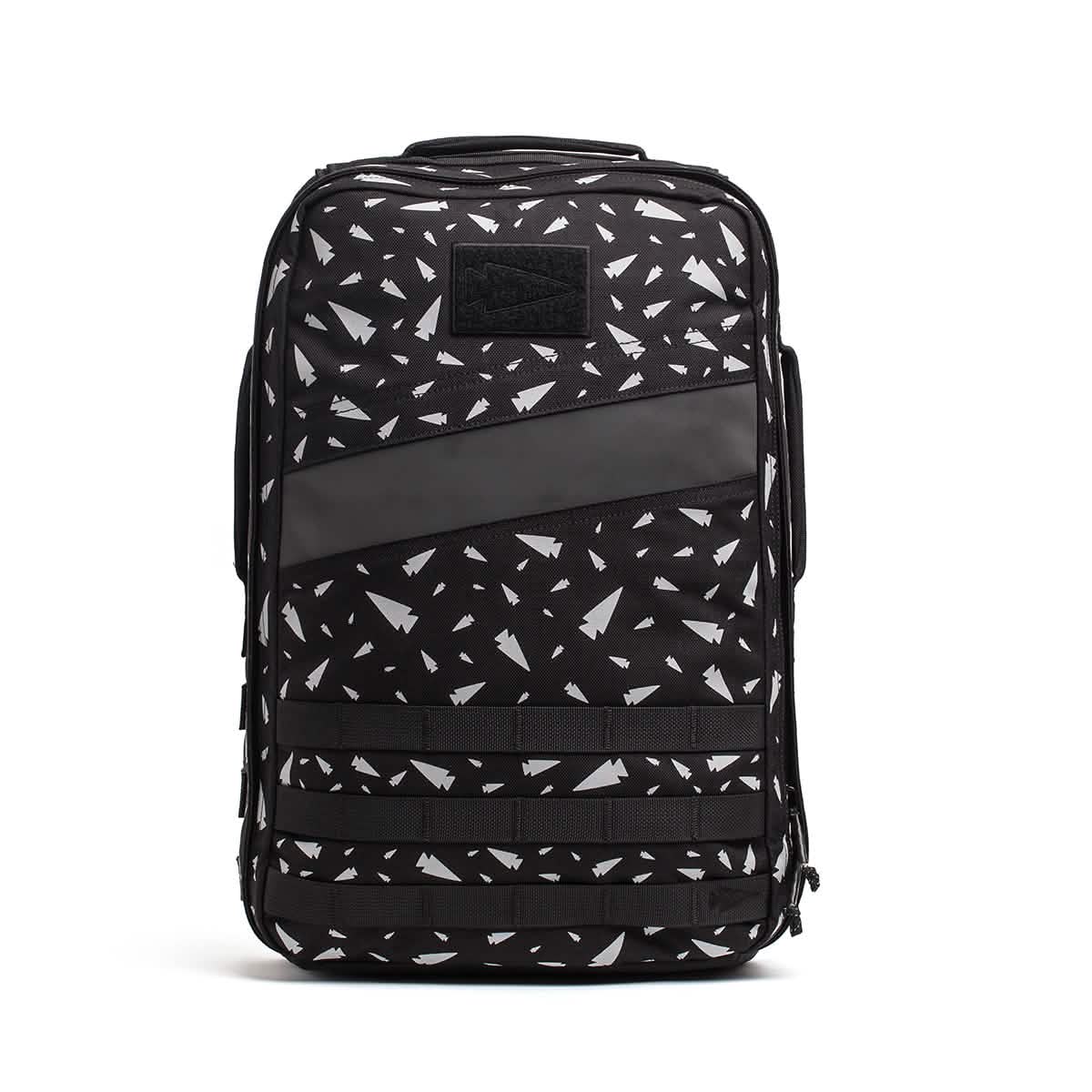 The Rucker 4.0 - Reflective Spearhead is a black backpack with a white geometric pattern, front pocket, side handle, and bold diagonal stripe—ideal for stylish training or daily use.