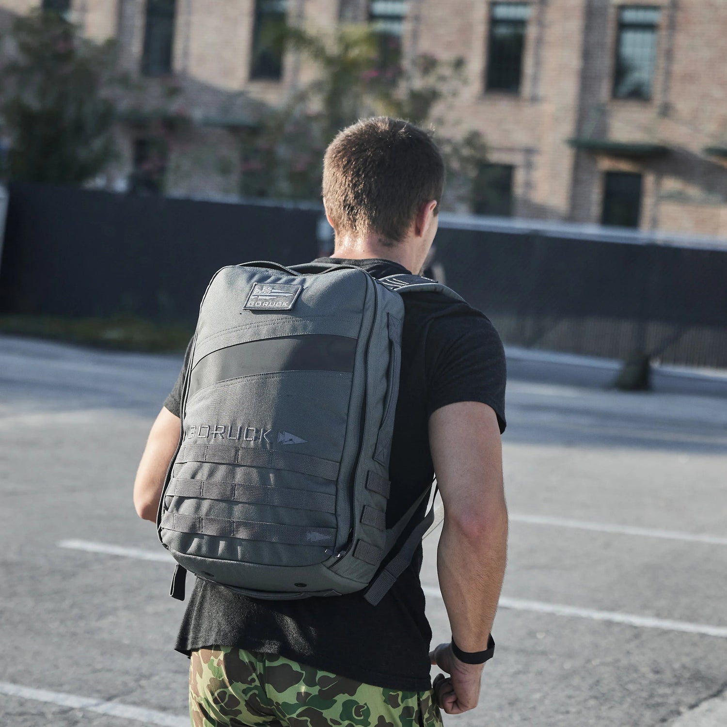Man wearing a GORUCK rucksack outdoors, showcasing durable rucking gear