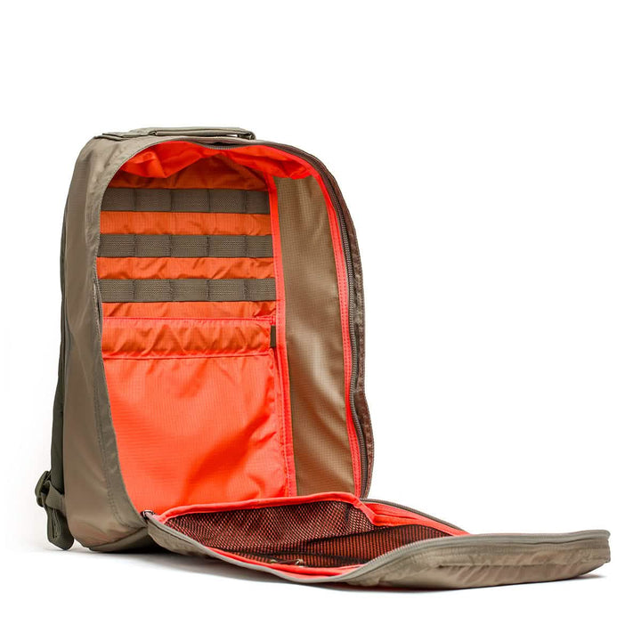 The GR1 USA - Ripstop ROBIC® by GORUCK is unzipped to display its interior, featuring numerous orange pockets and mesh compartments for organization. Its exterior, with a water-resistant light olive design, makes it ideal for any adventure.