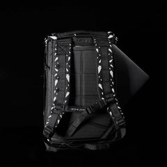 GORUCK backpack with padded straps featuring white arrowhead pattern, black back panel, and a laptop partially inserted