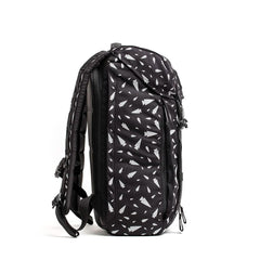 Black GORUCK backpack with white tree pattern, padded straps and multiple zippers, side view