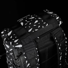 Close-up of black GORUCK rucksack with white tree pattern and padded shoulder straps on black background
