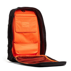 The GORUCK Rucker 4.0 backpack boasts a sleek black design with an open front flap that reveals a vibrant orange interior. Perfect for rucking, it includes multiple compartments and a convenient mesh pocket, making it the ideal rucksack for organized adventurers.