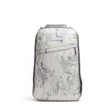 The GR1 is a light gray camo-patterned rucksack with a top handle and diagonal front zipper pocket, inspired by the iconic Special Forces backpack, displayed on a white background.