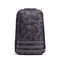 The GR1 USA - Cordura backpack features a black camo design, front zipper pocket, and horizontal straps, displayed against a white background.