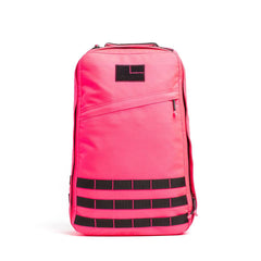 The GR1 USA - Cordura is a bright pink rucksack featuring a black patch and horizontal black straps on the lower front, inspired by Special Forces backpack design.