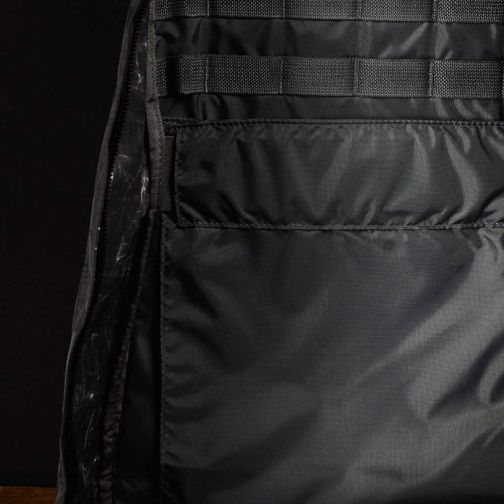 Here's a description based on the product data:

A close-up of the interior of an empty GR1 USA - Dyneema rucksack by GORUCK reveals a spacious main compartment featuring mesh-lined pockets and detailed stitching. The Dyneema® fabric exhibits a subtle sheen, with no visible items inside the backpack.