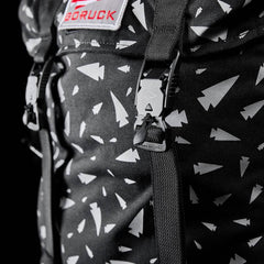 Close-up of black GORUCK rucksack with white arrowhead pattern and sturdy black buckle strap