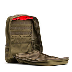 The GR2 - Cordura from GORUCK is a tactical backpack designed for Special Forces, featuring a zippered front that opens up to multiple compartments and mesh pockets. The interior showcases a bright red lining, and its design incorporates MOLLE webbing to attach extra gear—an authentic ruck that captures the essence of adventure.