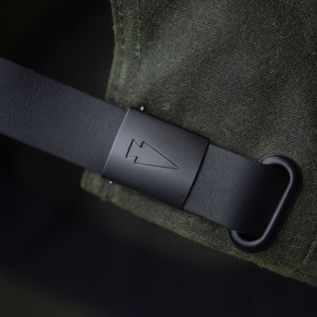 Tac Hat - Heritage with matte buckle featuring an engraved arrowhead symbol, shown against dark green fabric.
