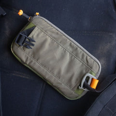 Sternum / Belt Pouch - CORDURA in khaki with black clips and orange accents sits on a dark fabric surface—perfect for rucking or keeping essentials hands-free.
