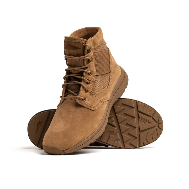 A pair of tan, mid-top tactical boots from GORUCK, specifically the MACV-1 Hi-Speed - Mid Top, designed for lightweight durability. One boot is upright while the other is tilted to display its textured sole. They come with laces and have a reinforced toe area, encapsulating the comfort and rugged design that define MACV-1™ rucking boots.