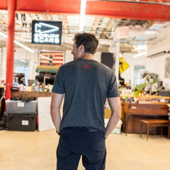 A man stands indoors with his back to the camera, showcasing the AmeRUCKa in a brightly lit, casual workspace.