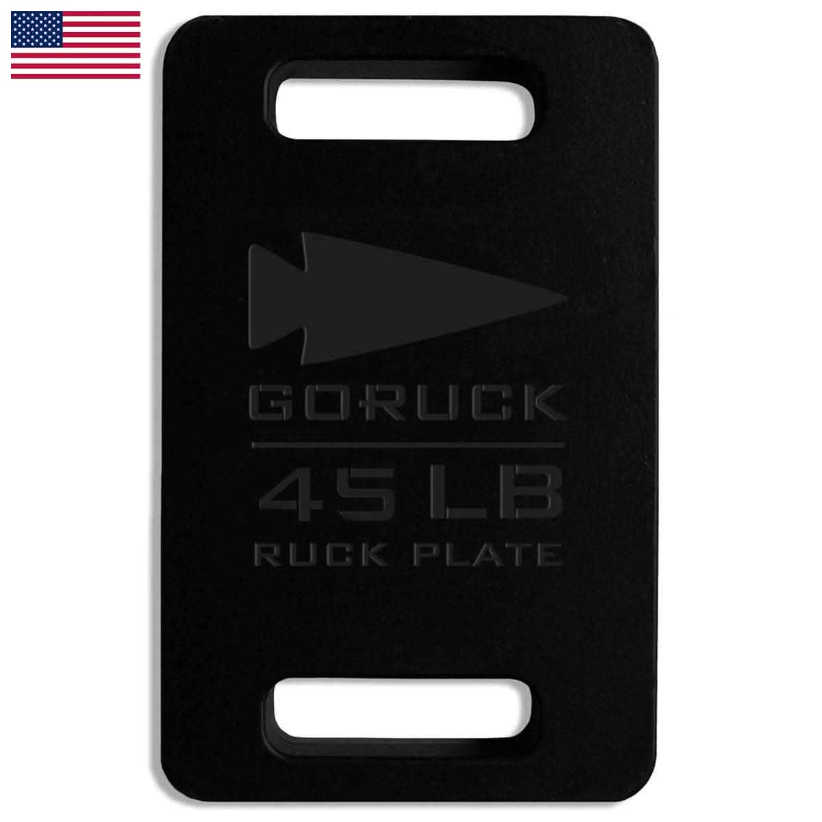 A Ruck Plate from GORUCK, weighing 45 LB and highlighted in black, exemplifies American craftsmanship. It includes two rectangular cutouts for easy transport, while an American flag is prominently displayed in the top left corner of the image, representing quality and durability.