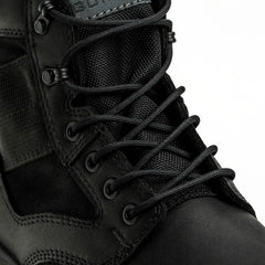 Close-up of black tactical boot with rugged leather and mesh, featuring durable laces and metal eyelets
