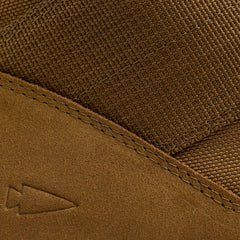 Close-up of a GORUCK MACV-2 high-top in coyote suede showing off textured fabric and visible stitching, evocative of classic jungle boots. A small embossed arrow logo on the suede adds a unique touch to its rugged style.