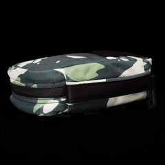 Against a black backdrop lies the GR1 Field Pocket x Gear Patrol by GORUCK, a compact, zippered pouch adorned with a green, black, and white Variegated Elephant Ear Camo pattern.