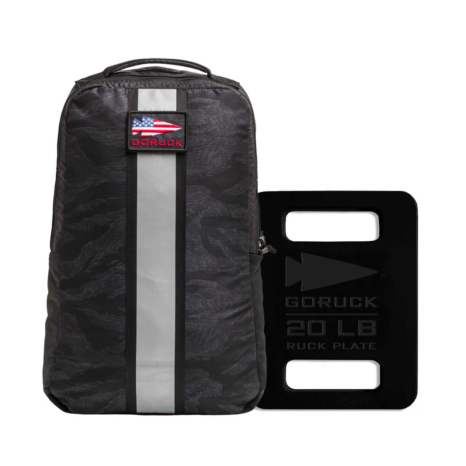 The Basic Rucker + FREE Plate is a black backpack with a U.S. flag patch and includes a GORUCK 20LB Ruck Plate, ideal for weighted training.