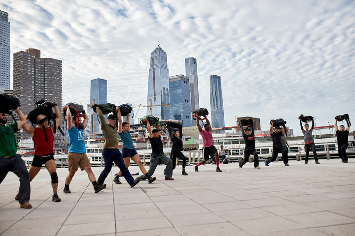 A group of people walking with bags on their heads.
