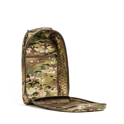 The Bullet X-PAC daypack, featuring a camouflage pattern, is open to show an empty main compartment with inner mesh pockets and tough AquaGuard zippers.