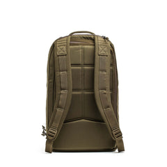 The Double Compartment Bullet Ruck (18L) in olive green is shown from the back, featuring padded shoulder straps, a top handle, and a bombproof laptop compartment. Made with durable Ballistic Nylon Cordura.