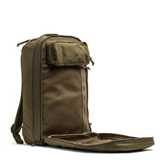 The olive green Double Compartment Bullet Ruck - Ballistic Nylon Cordura - 18L stands upright with its front compartment unzipped to show mesh pockets inside—ideal for travel and keeping your gear organized on the go.