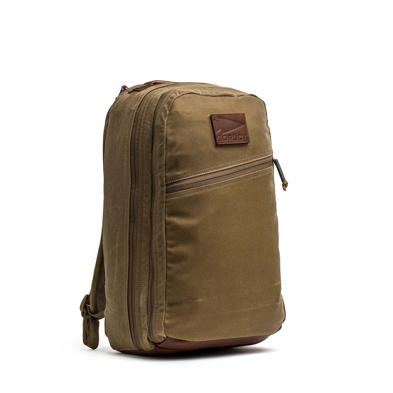 The Double Compartment Bullet Ruck - Heritage Waxed Canvas - 18L features a brown waxed canvas, leather accents, front pocket, and side zipper—perfect as a stylish daypack for travel or daily use.