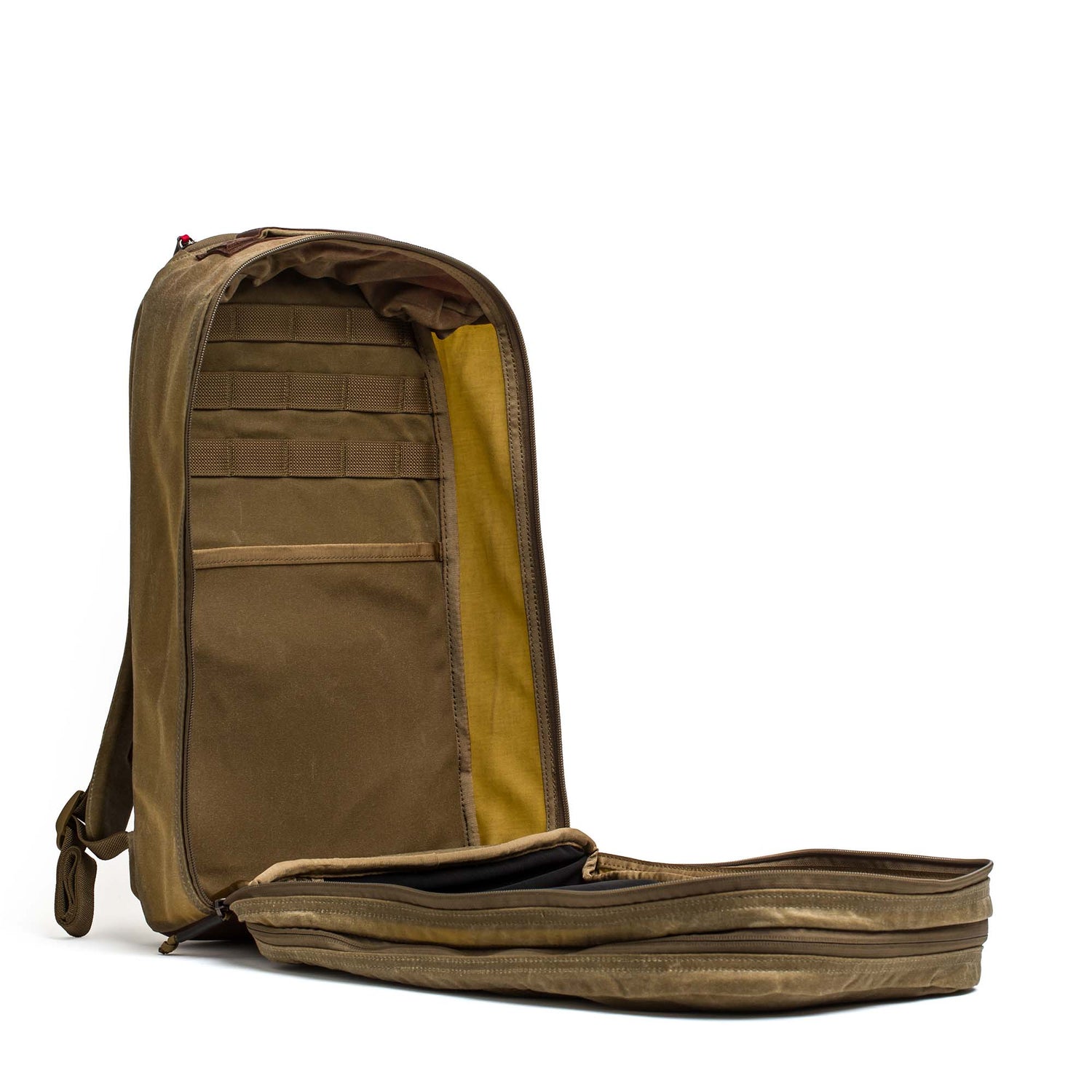 The Double Compartment Bullet Ruck - Heritage Waxed Canvas - 18L stands upright with its main compartment unzipped, revealing interior pockets and a yellow lining—a stylish daypack for travel or everyday adventures.