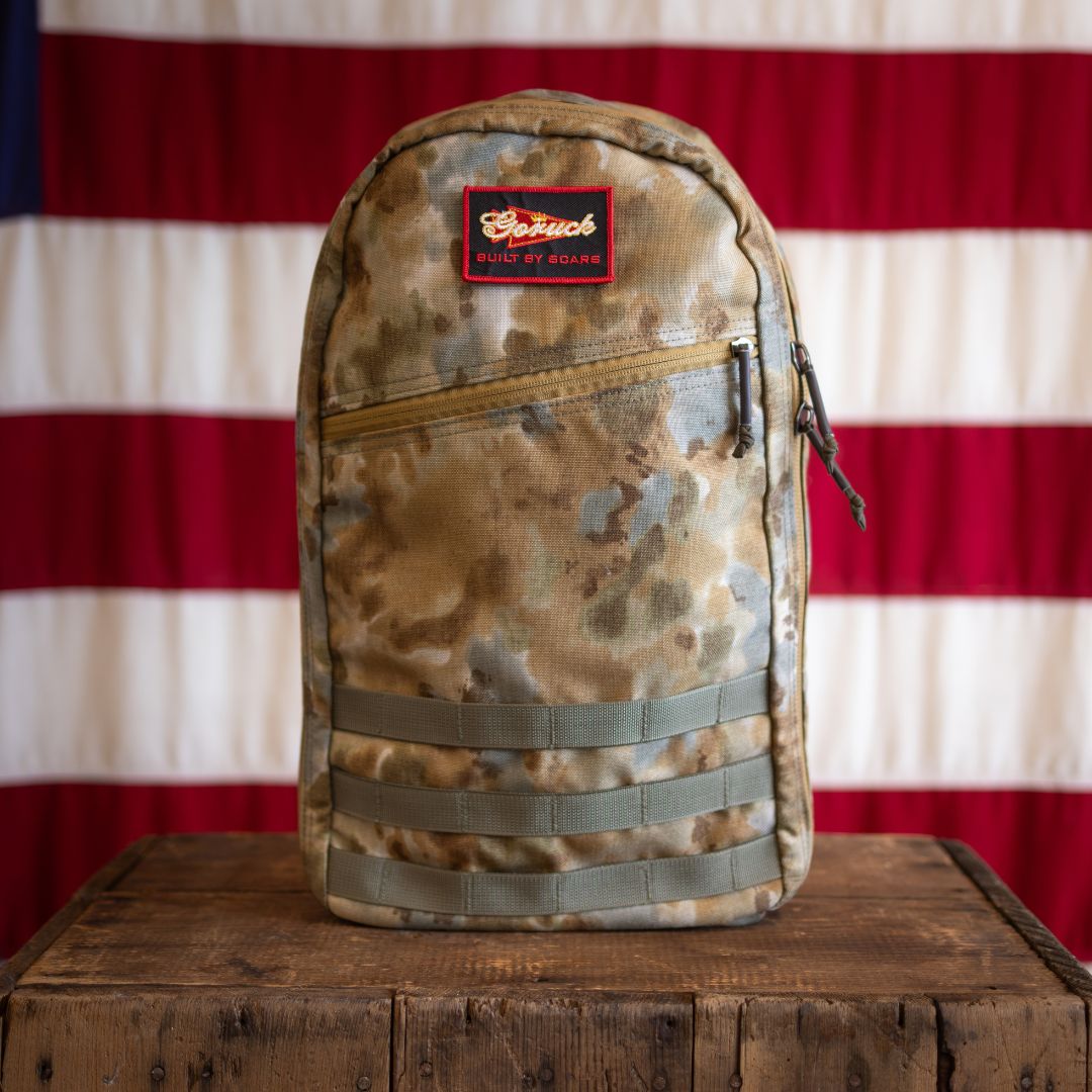 Arid Bullet - Built by Scars in camouflage on wood, set against a limited edition flag backdrop.