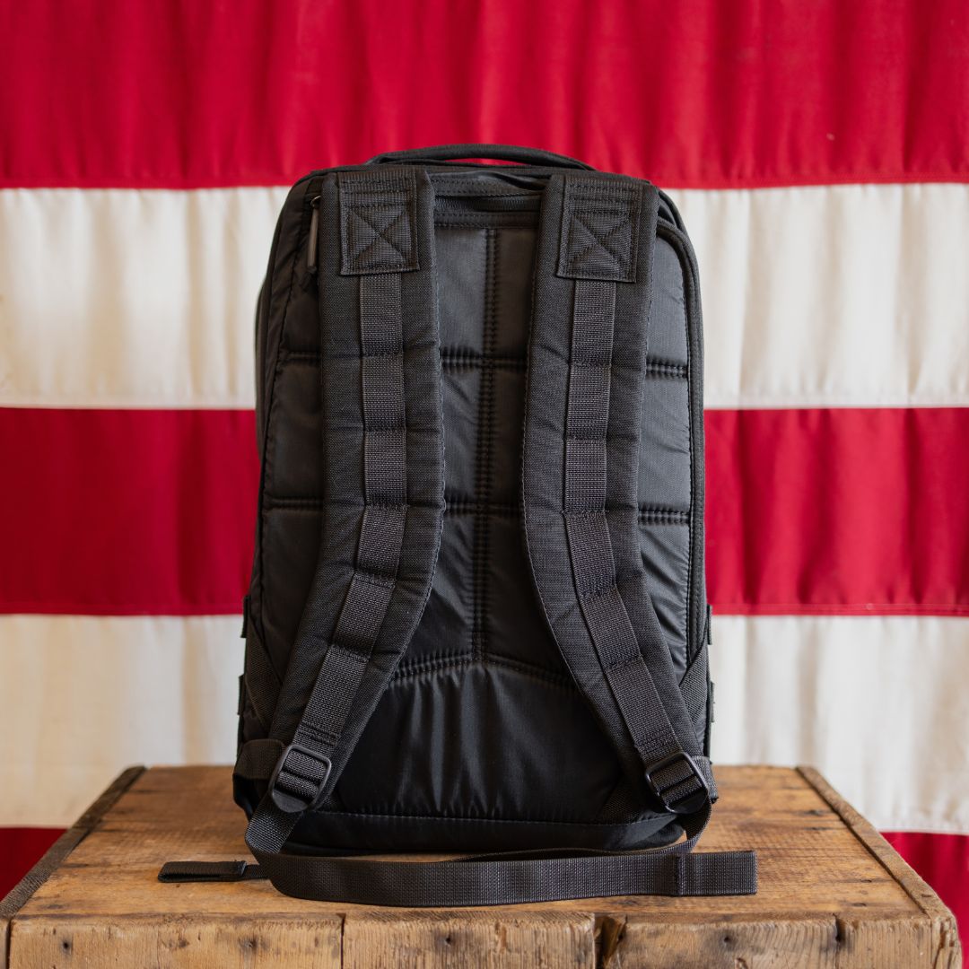 13 Stars GR1 21L - Built by Scars with padded straps on table, red and white stripes in background.