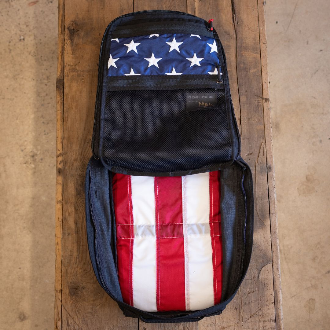 13 Stars GR1 21L - Built by Scars open on a wooden table, showing its American flag backpack lining inside.