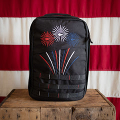 Limited edition Fireworks GR1 21L - Built by Scars, handmade in the USA, shown on a wooden box before a flag.