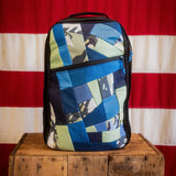 Shooter 26L Mosaic - Built by Scars sits on a wooden box in front of a US flag.