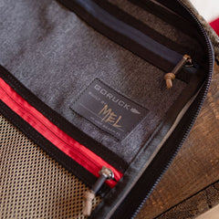 Interior view of a handmade GORUCK storage pouch from Jax Beach, FL, featuring a patch reading “Built by Mel in Jax Beach FL” and a red-trimmed mesh pocket.