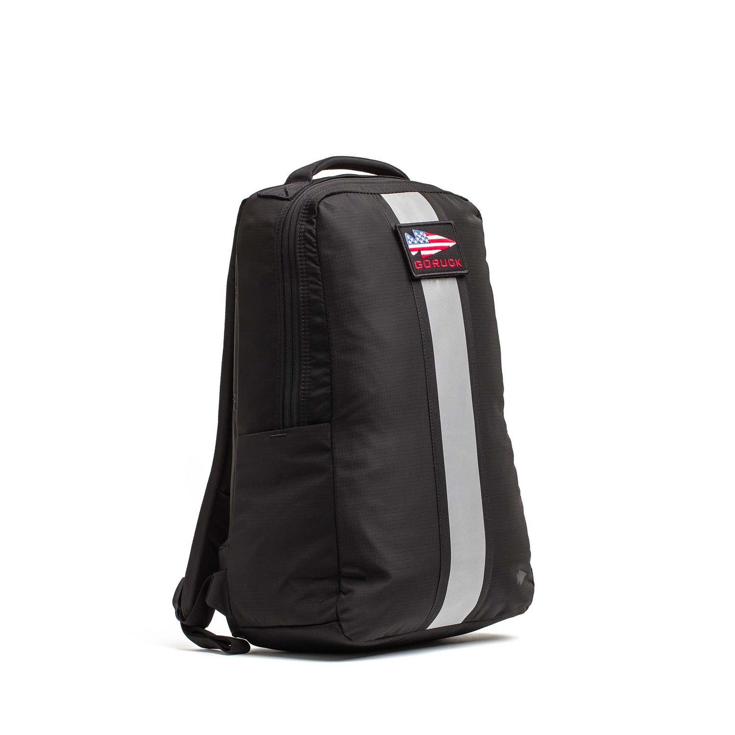 The Basic Rucker is a black backpack featuring a vertical reflective stripe and a rectangular patch on the front, designed to stand upright and comfortably fit your preferred ruck plate—making it perfect for your next rucking workout.