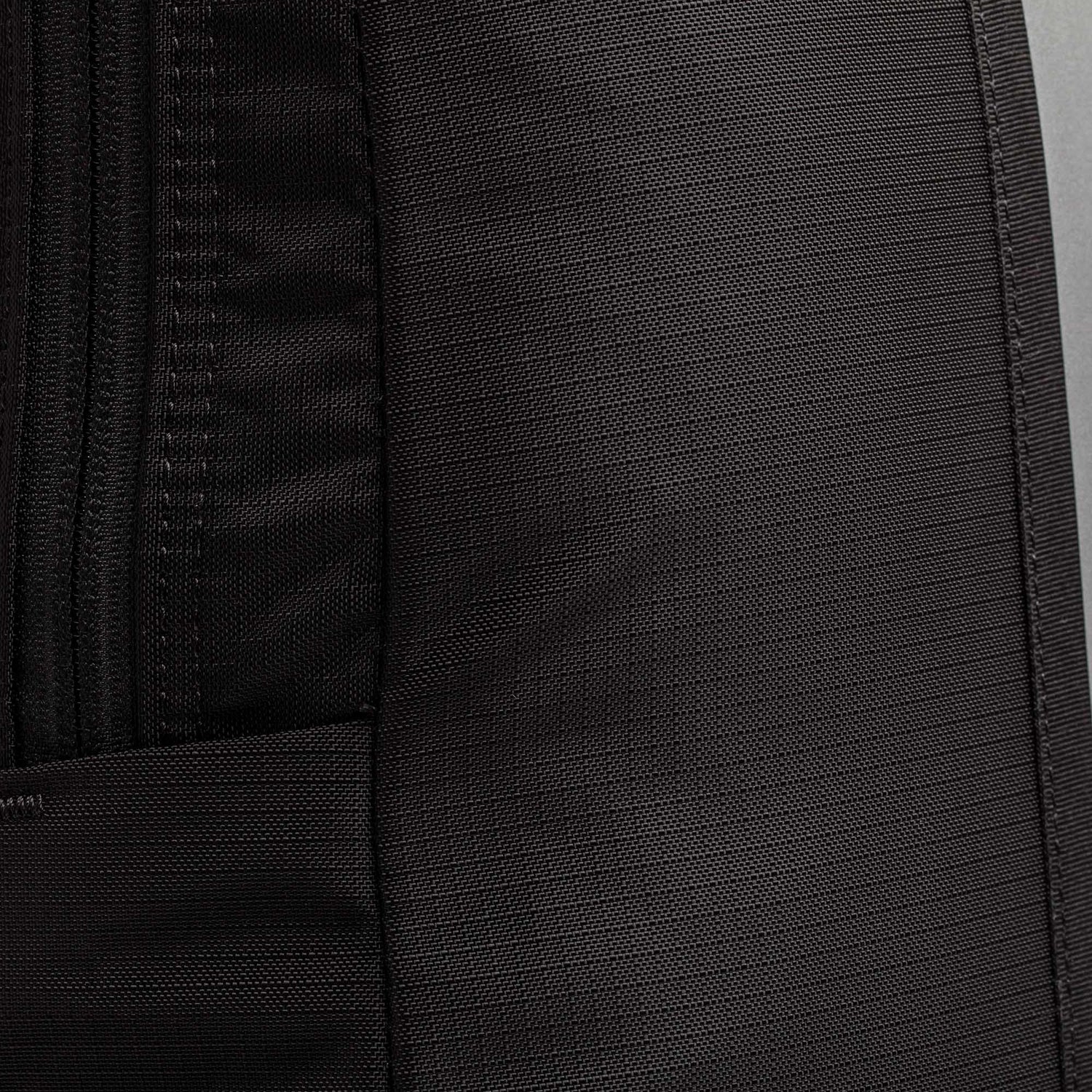 Close-up of a black fabric Basic Rucker backpack, featuring a visible zipper and textured material—perfectly suited for rucking or pairing with your favorite ruck plate.
