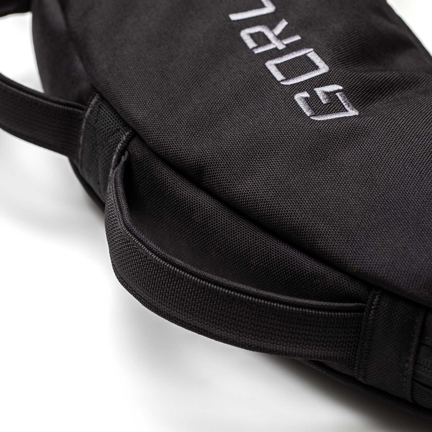 Close-up of a black Bulgarian Sandbag with stitched handles and partial white embroidered text.