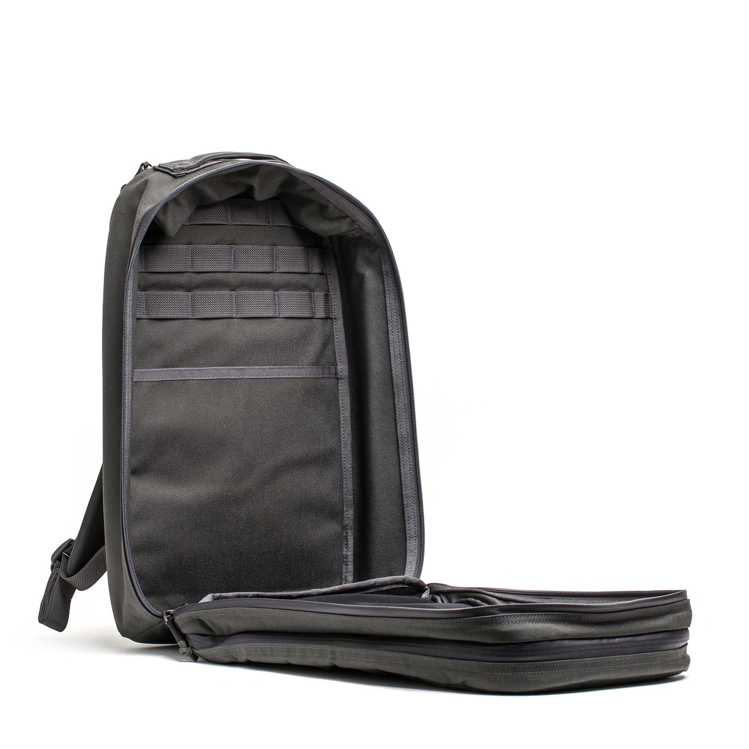 The Double Compartment Bullet Ruck - Ballistic Nylon Cordura - 18L stands upright with its main compartment fully unzipped, showcasing a secure laptop section and organized interior pockets in this sleek, durable backpack.