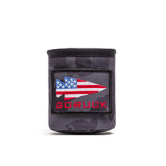 The Ballistic Beer Jacket - GORUCK is a gray 1000D CORDURA koozie featuring an American flag arrow patch and bold red "GORUCK" text on the front for a rugged, patriotic look.