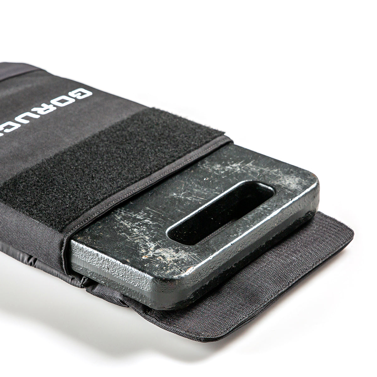 The RPC Long + 30LB (Long) Plate Bundle features a black metal ruck plate partially inside a fabric pouch with a velcro strap, ideal for weighted training.