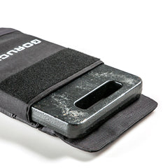 The RPC Long + 30LB (Long) Plate Bundle features a black metal ruck plate partially inside a fabric pouch with a velcro strap, ideal for weighted training.