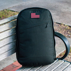 GORUCK black rucksack backpack with flag patch on bench outdoors